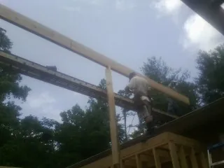 Carpenter setting a ridge beam over a new addition frame — Ice Dam Removal by Roofing Brothers in Ochlocknee